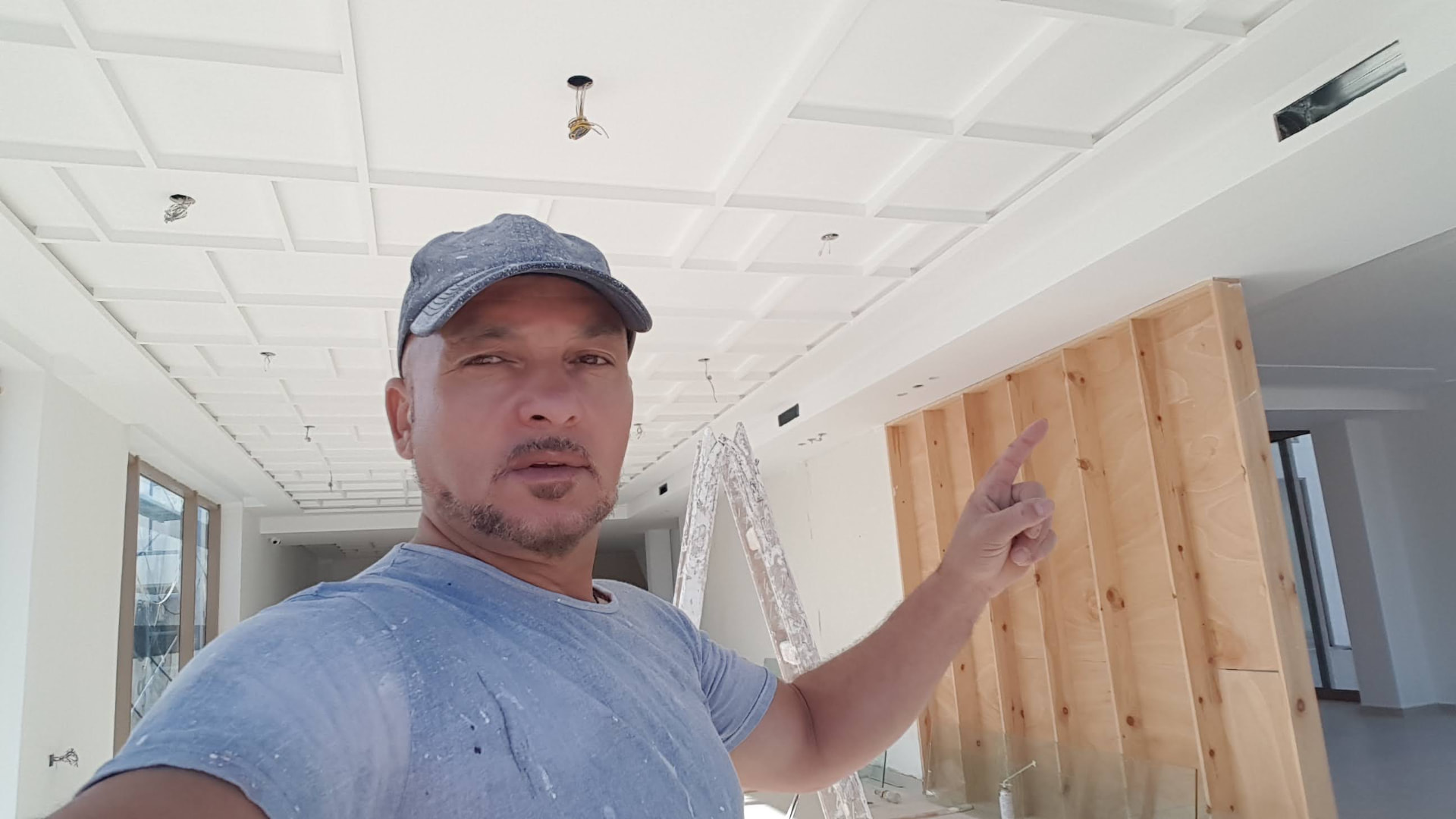 L'artisan présentant un chantier de faux plafond à caissons